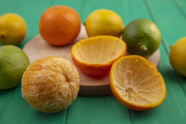 绿色前视图剥皮橙色与果皮和柠檬与酸橙绿色背景柠檬橘子前面