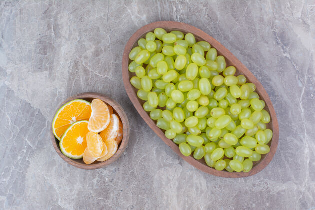 新鲜一束绿色的葡萄放在木盆里 还有柑橘类水果水果自然橘子