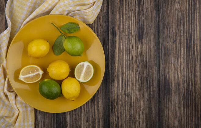 复制顶视图复制空间柠檬与柠檬在黄色板与黄色格子毛巾在木制背景上空间柑橘黄色