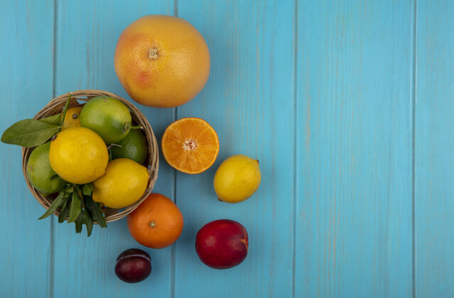 篮子顶视图复制空间葡萄柚与橙子柠檬与酸橙在一个蓝绿色的背景篮子柠檬复制柑橘