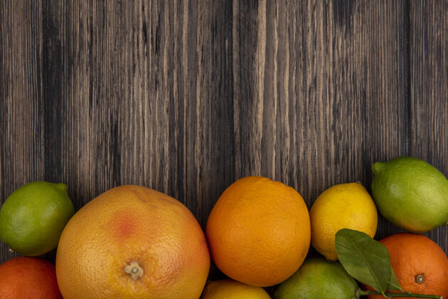 复制顶视图复制空间葡萄柚与橙子柠檬和酸橙木背景柠檬酸橙食物