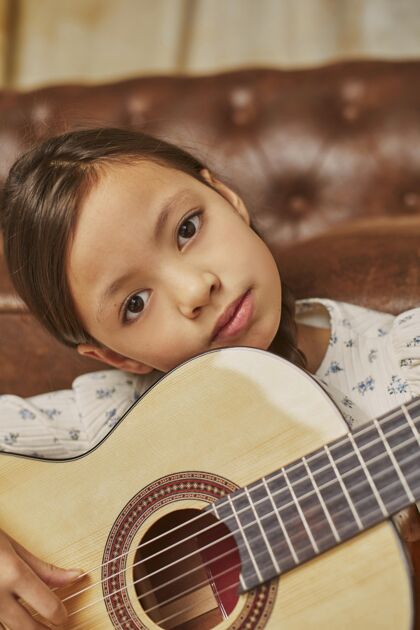 课小女孩在家弹吉他女孩音乐家表演