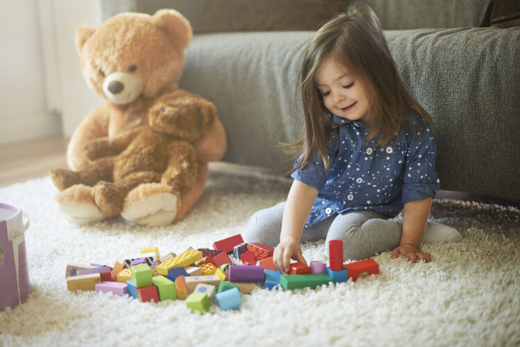 欢乐小女孩在客厅玩玩具沙发技能积木