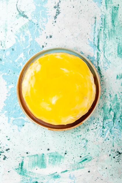 白鸡蛋俯瞰美味的蛋糕 在蓝色的表面上涂上黄色糖浆饼干蛋糕烘烤甜甜的饼干糖茶黄油蛋糕糖浆