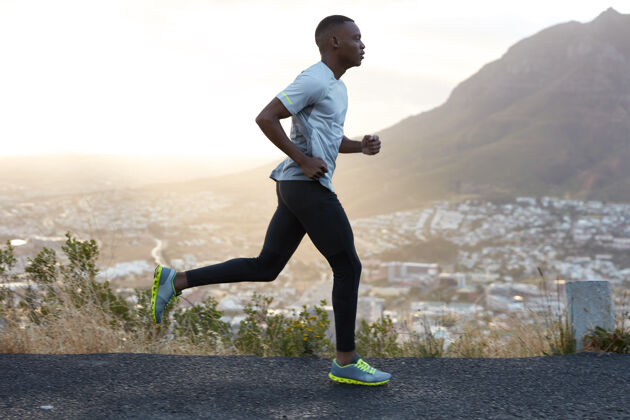 决心户外拍摄的活跃的黑皮肤男子上午跑步 有规律的训练 穿着运动服和舒适的运动鞋 集中到远处 看到终点很远路线人乡村