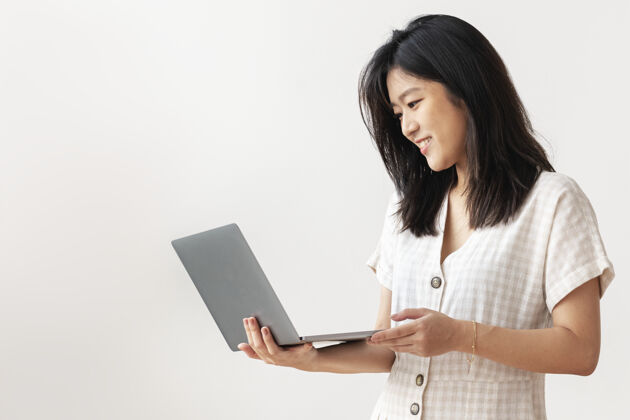 女性快乐的亚洲女人在家工作平原电脑女性