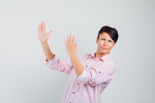空手道女性在粉色衬衫前视图中显示空手道斩动作流感保护砍