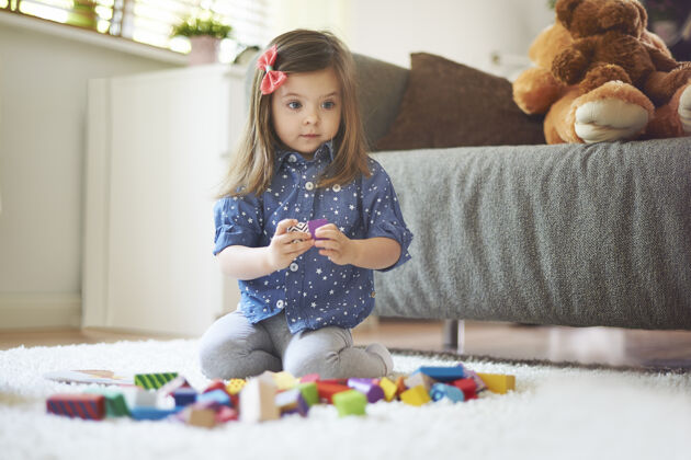 地毯小女孩在客厅玩玩具成长坐着教育
