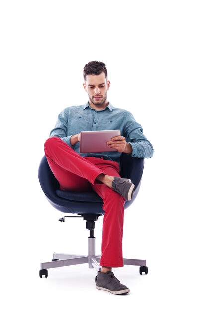 坐着使用数字平板电脑的时尚年轻人电脑人科技