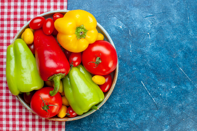 颜色顶视图新鲜蔬菜樱桃西红柿不同颜色甜椒西红柿在碗里红色和白色格子桌布在蓝色的桌子上复制空间桌布碗新鲜蔬菜