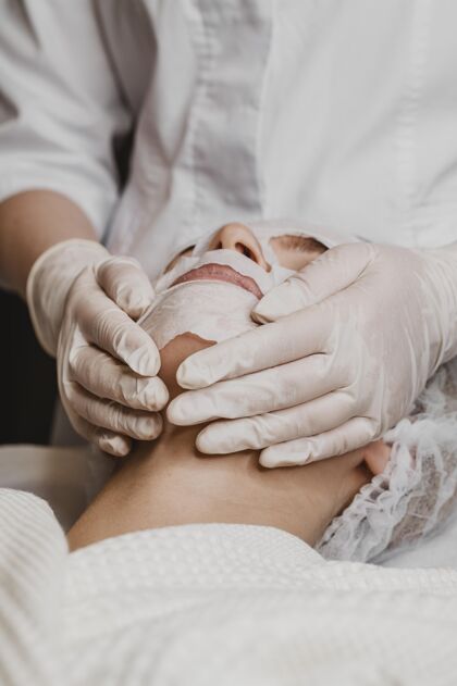 皮肤护理年轻漂亮的女人正在接受皮肤面膜治疗过程护理美容师