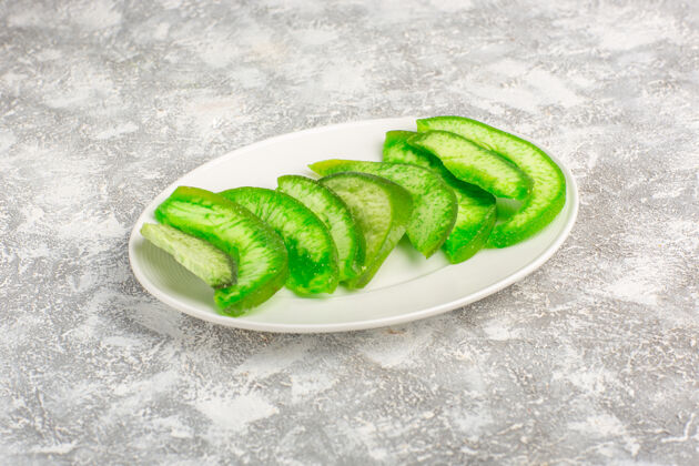绿豆前视图切片绿色黄瓜内板上的白色表面盘子绿豆蔬菜