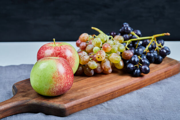 热带苹果和葡萄串在木板上健康组合季节