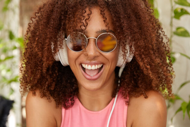 美国快乐时尚的非洲发型少年的照片耳机脆流行