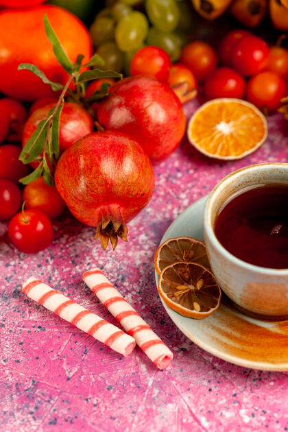 饮食前视图新鲜水果组成 浅粉色表面上有一杯茶维生素水果水果