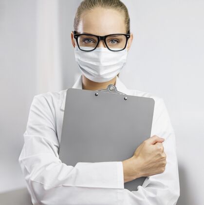 女戴着医用面罩和剪贴板的女科学家的正面图技术员实验室技术员发明家