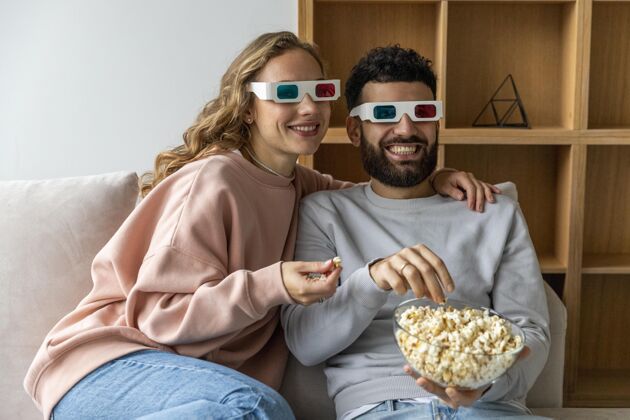 爱笑脸夫妻在家吃爆米花 戴着立体眼镜看电影伙伴浪漫女人
