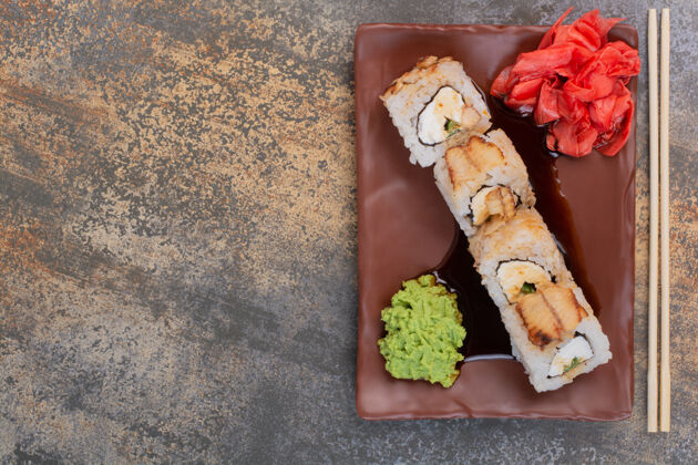 五颜六色一套美味的寿司 用筷子和姜放在大理石表面筷子寿司黄瓜棒