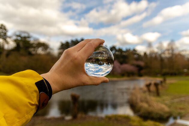 光手拿着一个玻璃球在大自然写自然圆