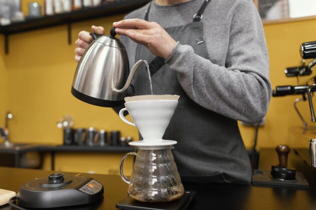 职业男咖啡师用咖啡过滤器倒水工作咖啡师水平