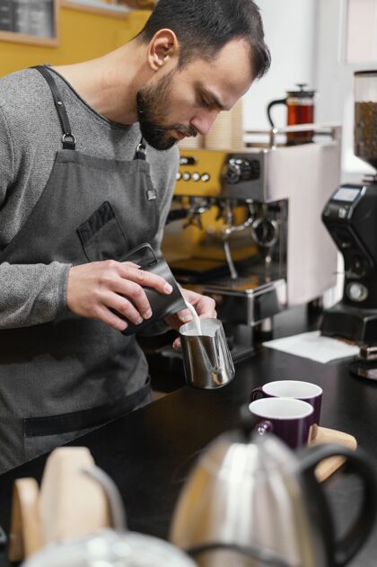 工作男咖啡师准备咖啡的侧视图男性雇员咖啡师