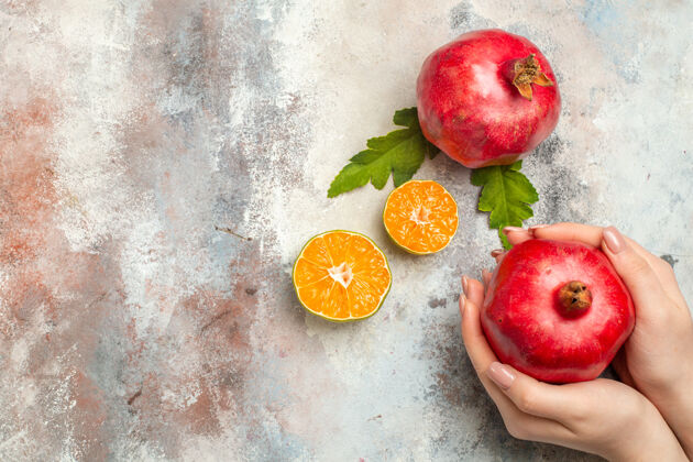 苹果俯瞰红石榴在女性手上柠檬片裸体表面的自由空间吃苹果多汁顶部