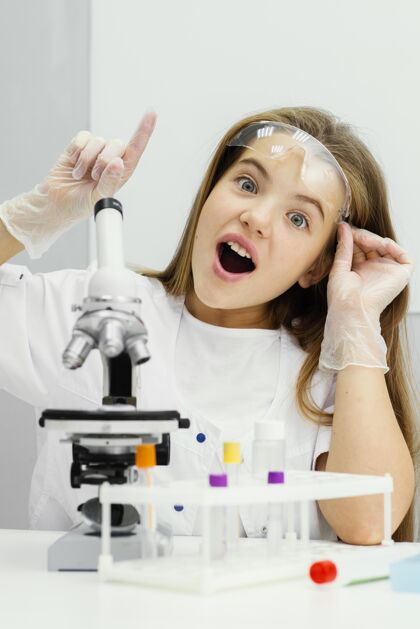 思想年轻的女科学家用显微镜和有想法的前视图垂直试管科学