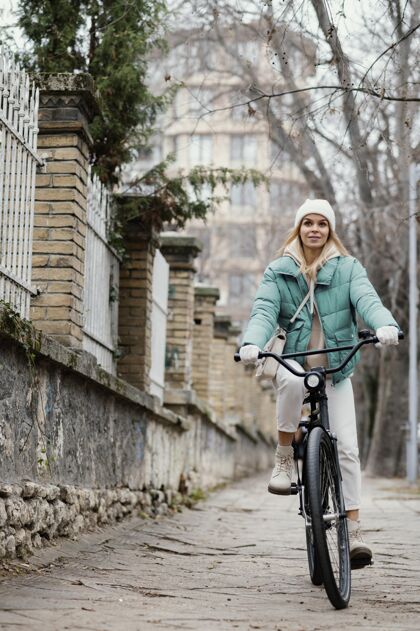 自行车在人行道上骑自行车的女人城市街道齿轮