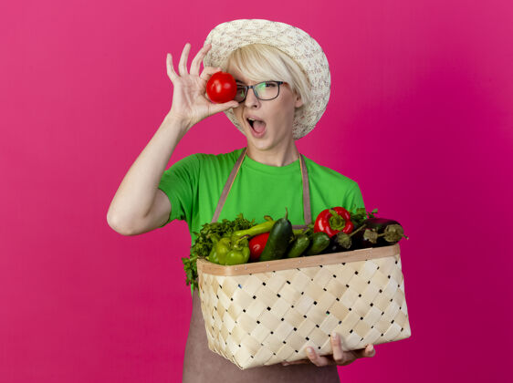 帽子一位年轻的园丁 围着围裙 戴着帽子 手里拿着装满蔬菜的箱子抱着短裤蔬菜
