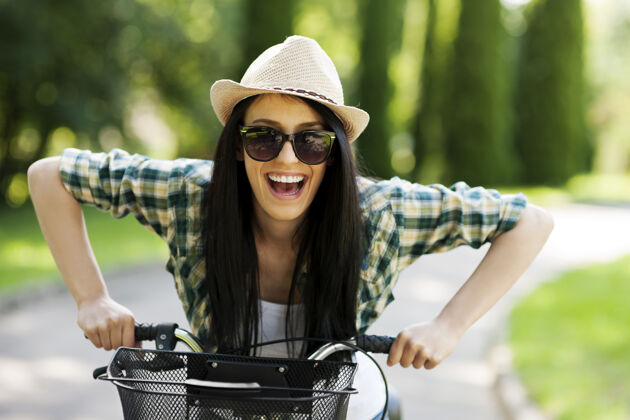 自行车骑自行车的快乐年轻女子帽子篮子骑自行车