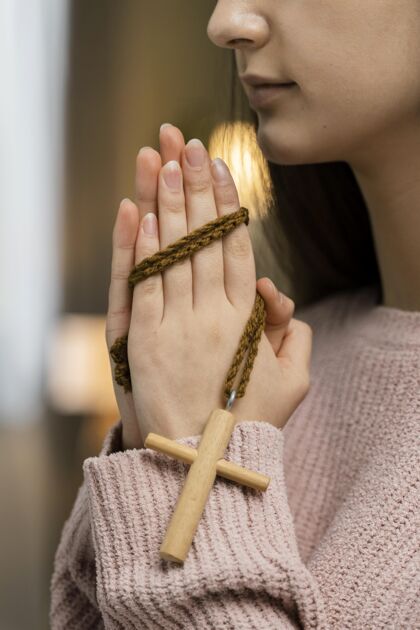 圣洁妇女用木十字架祈祷的侧视图教义崇拜奉献