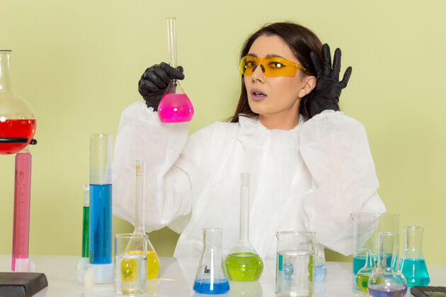 工作前视图穿着特殊防护服的女化学家在浅绿色表面处理溶液套装浅绿色医学