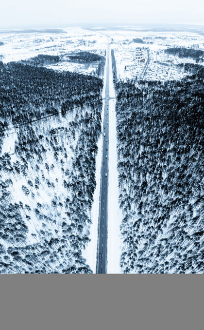 季节一条被冷杉树和雪包围的道路的垂直镜头道路汽车垂直