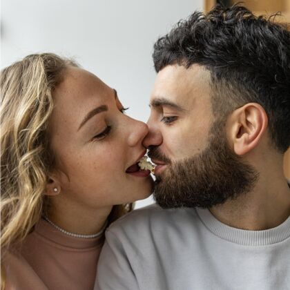 关系浪漫情侣在家里用爆米花接吻伙伴男人平方