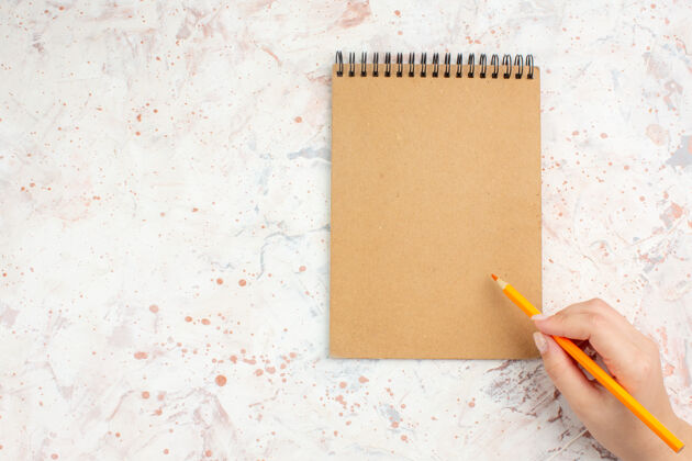 铅笔顶视图笔记本橙色铅笔在女性手中明亮的孤立表面与复制空间笔记本视图古董