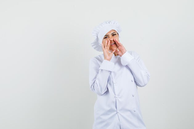 职业穿白色制服的女厨师手贴嘴讲秘密美食讲述专业