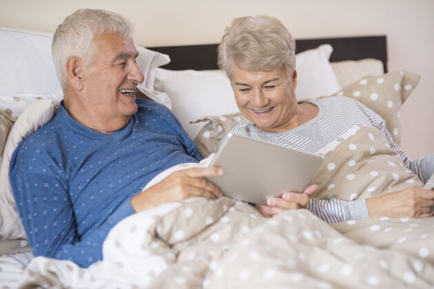 异性恋夫妇现代的祖父母在卧室休息微笑睡衣躺着