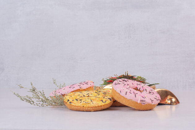 黄色白色表面有四个五颜六色的甜甜圈好吃粉色面包房