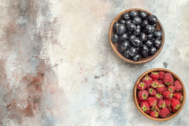 碗顶视图树莓和葡萄在碗上裸体孤立的表面自由的地方黑莓胡椒浆果