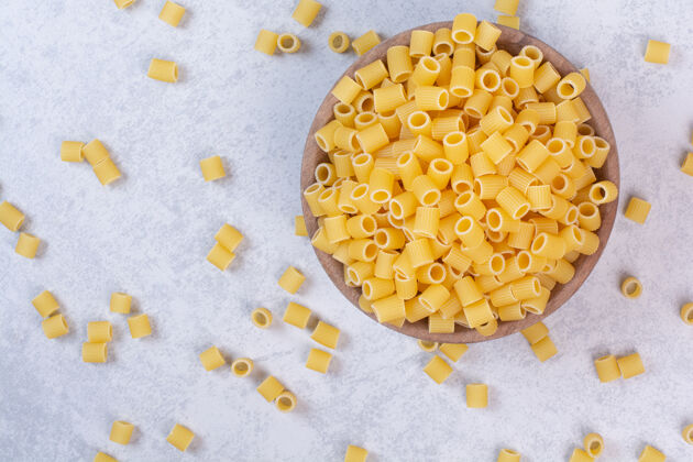 碗新鲜的生通心粉放在木盘上意大利面意大利面黄色