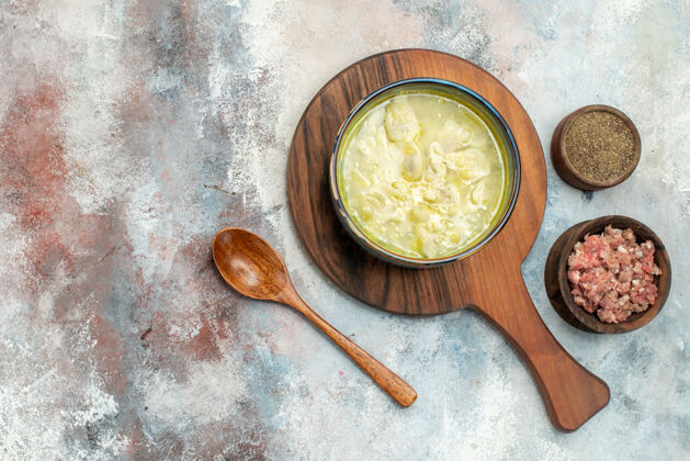 观点俯瞰杜什巴拉饺子汤在砧板碗上用肉和胡椒木勺在裸体表面自由摆放肉木勺地方