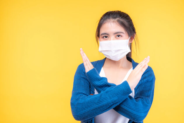 手戴着口罩的亚洲女孩展示停止双手的手势 以阻止电晕病毒的爆发担心卫生冠状病毒