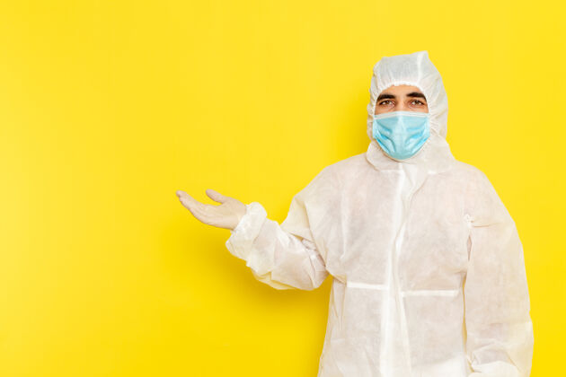 正面身穿白色防护服 带面罩 浅黄色墙壁的男性科学工作者正面图危险实验室外套浅黄色
