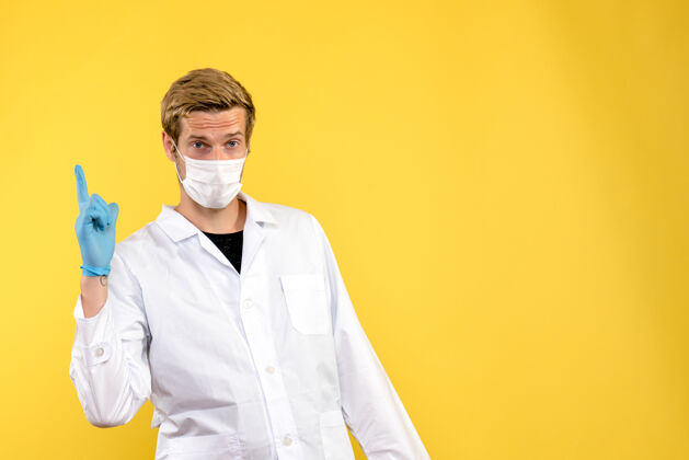 长相正面图黄色背景上的男医生大流行冠状病毒健康病毒商人服装医生