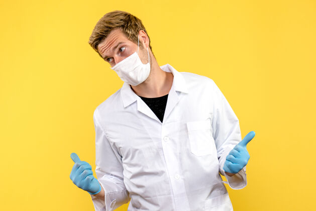 专业正面图黄色背景上的男医生大流行的冠状病毒-健康病毒病毒男性外套