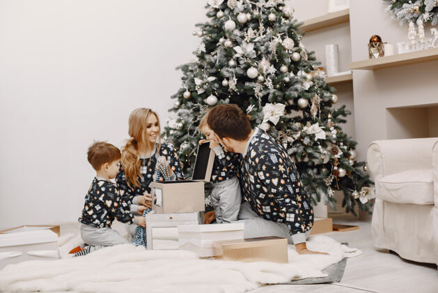 欢乐人们在修理圣诞礼物 人们在和孩子玩耍 一家人在节日的房间里休息圣诞房子黑发