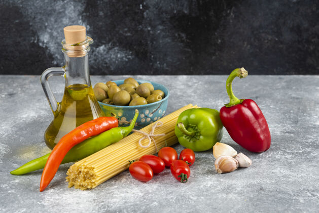 橄榄石桌上有意大利面 油和各种蔬菜生的食品意大利面
