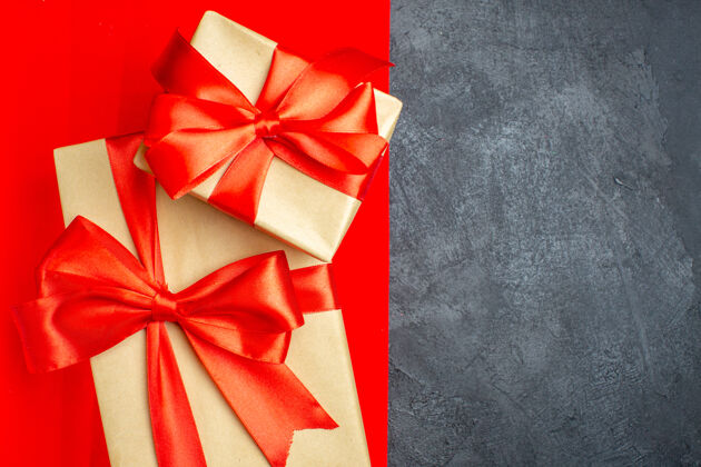 轮子俯瞰美丽的礼物与红色和黑色背景上的蝴蝶结形缎带弓弓形圣诞节