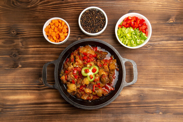 菜在棕色的桌子上 俯瞰烹饪蔬菜餐和调味品和切好的甜椒顶部盘子食物