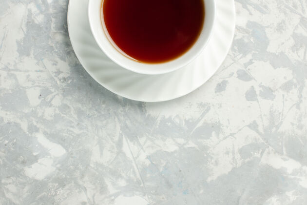 茶托顶视图浅白色表面上的一杯热茶杯子饮料